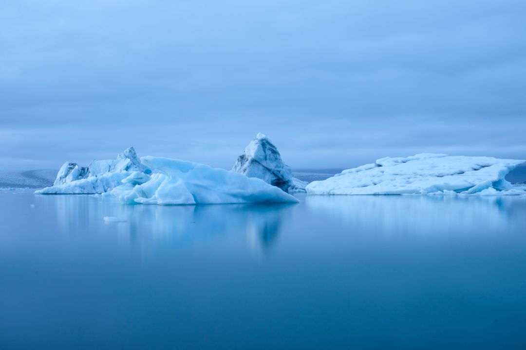 Blue Icebergs Floating in Calm Glacial Lagoon Reflecting Soft Twilight Light
