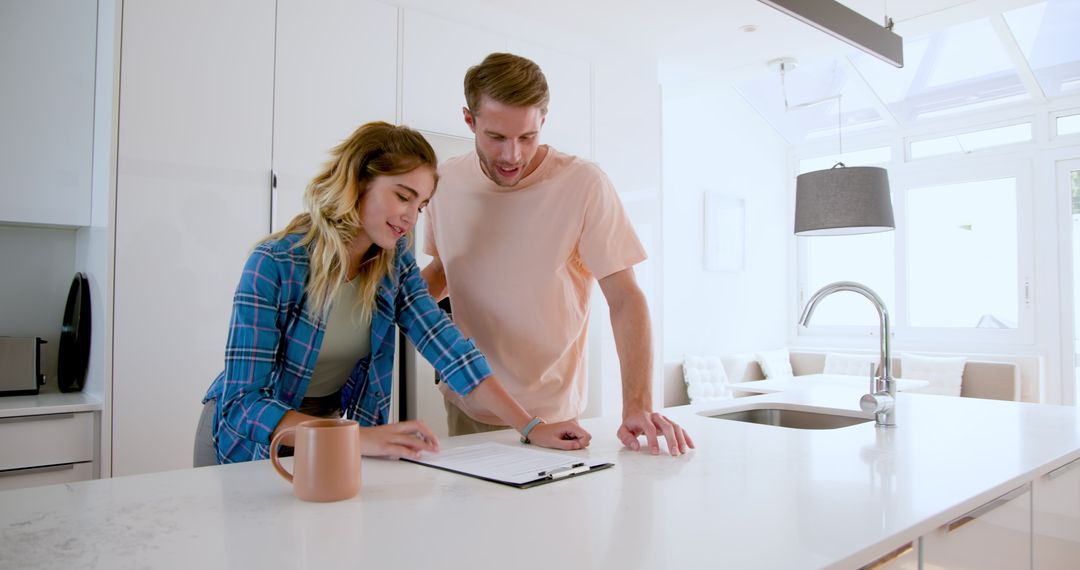 Happy Couple Reviewing Documents in Kitchen for Future Planning