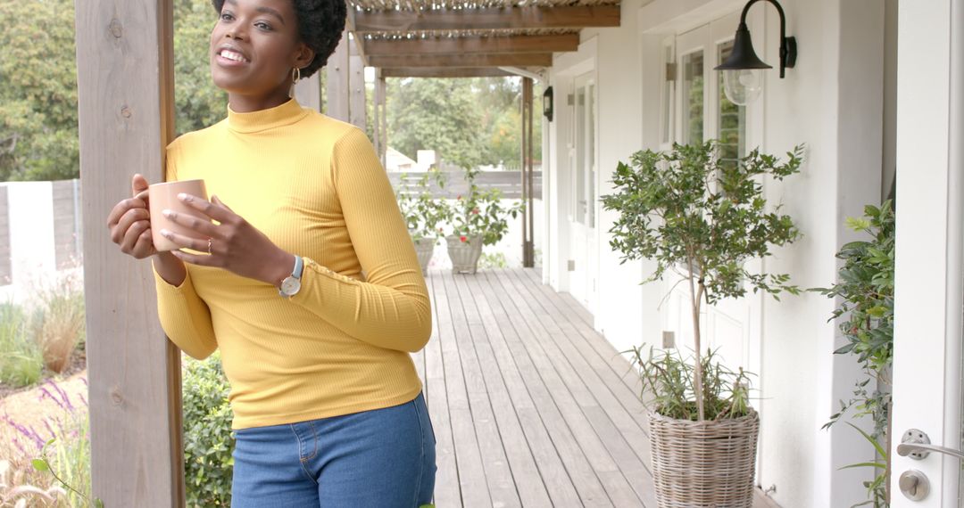 African American Woman Enjoying Coffee on Sunny Porch in Rustic Setting