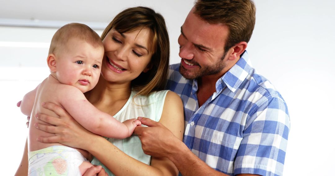 Happy Parents Holding Toddler in Their Home - Free Images, Stock Photos and Pictures on Pikwizard.com