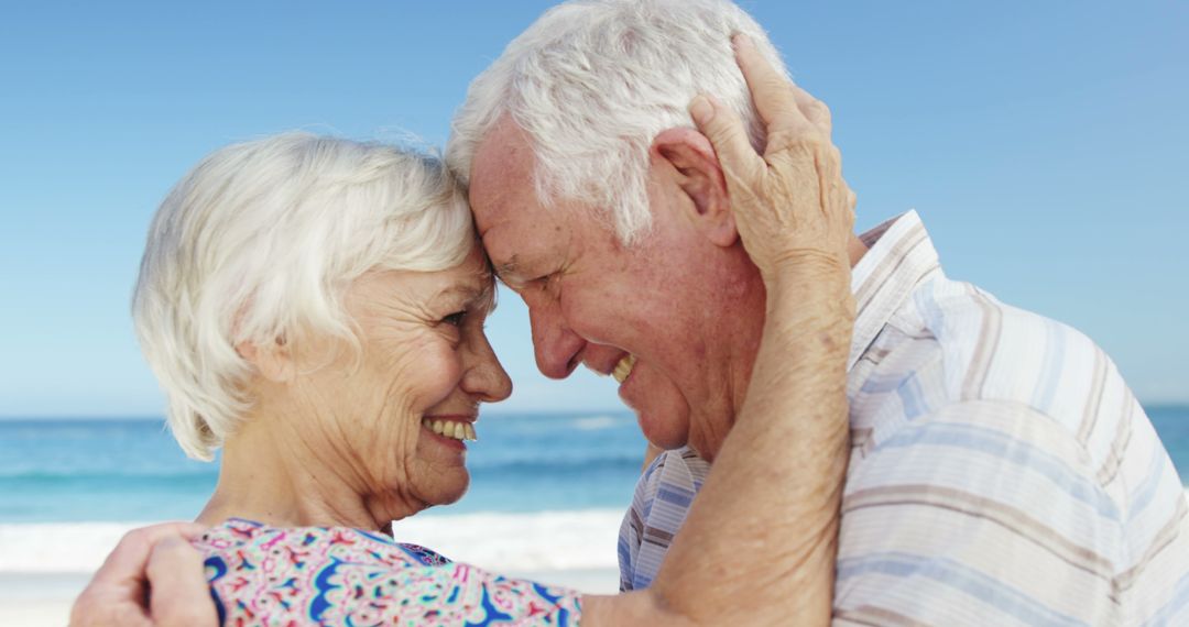 Elderly Couple Embracing and Smiling on Beach - Free Images, Stock Photos and Pictures on Pikwizard.com