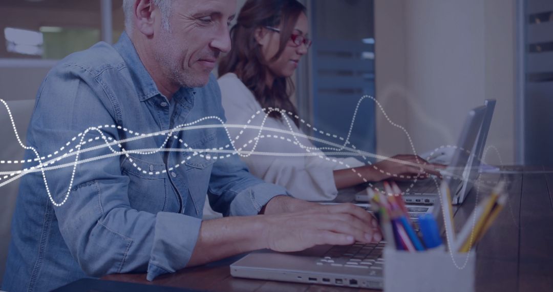 Colleagues Collaborating on Laptops in Modern Office