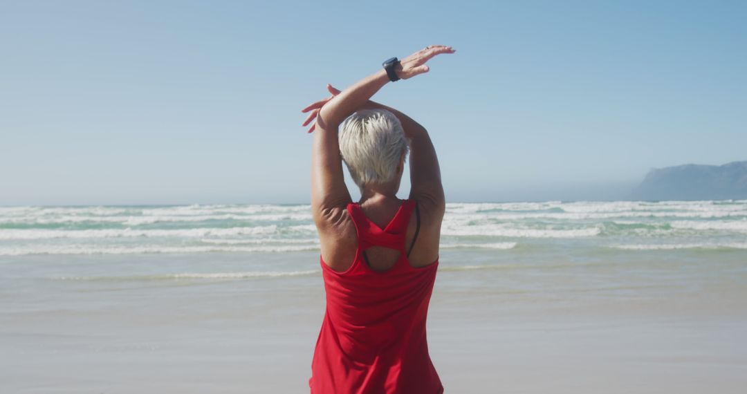 Active Senior Woman Stretching on Ocean Beach - Free Images, Stock Photos and Pictures on Pikwizard.com