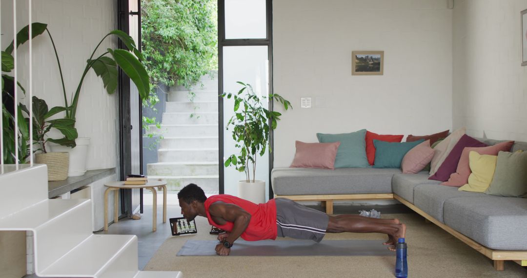 Man Doing Push-Ups in Living Room Watching Online Workout - Free Images, Stock Photos and Pictures on Pikwizard.com