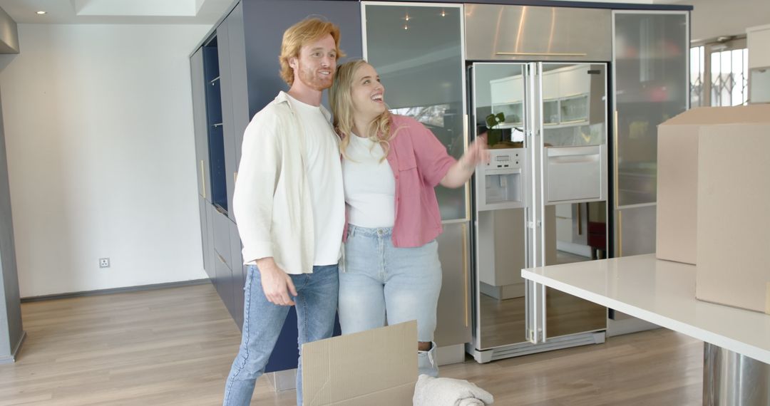 Happy Couple Embracing During Home Move in Modern Kitchen