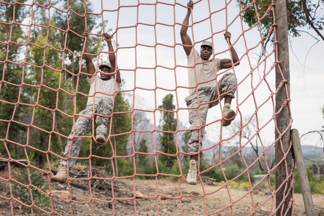 Military soldiers climbing a net during obstacle course - Free Images, Stock Photos and Pictures on Pikwizard.com