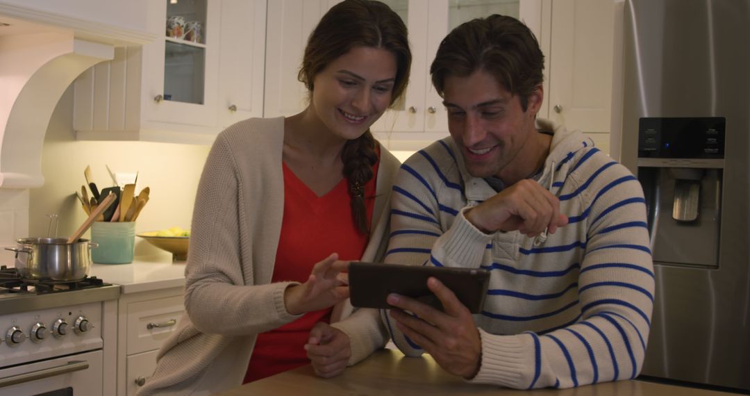 Happy Couple Using Tablet for Recipe in Cozy Kitchen