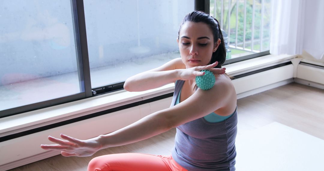 Young Caucasian woman performs arm stretches at home - Free Images, Stock Photos and Pictures on Pikwizard.com