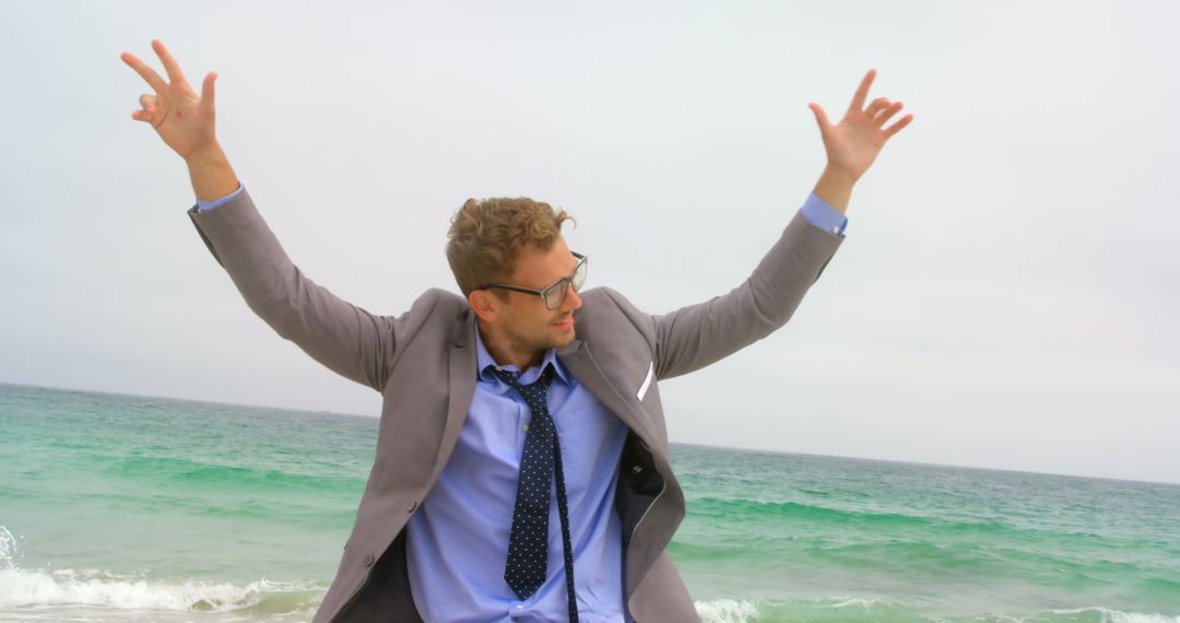 Joyful Businessman Dancing on Beach in Suit