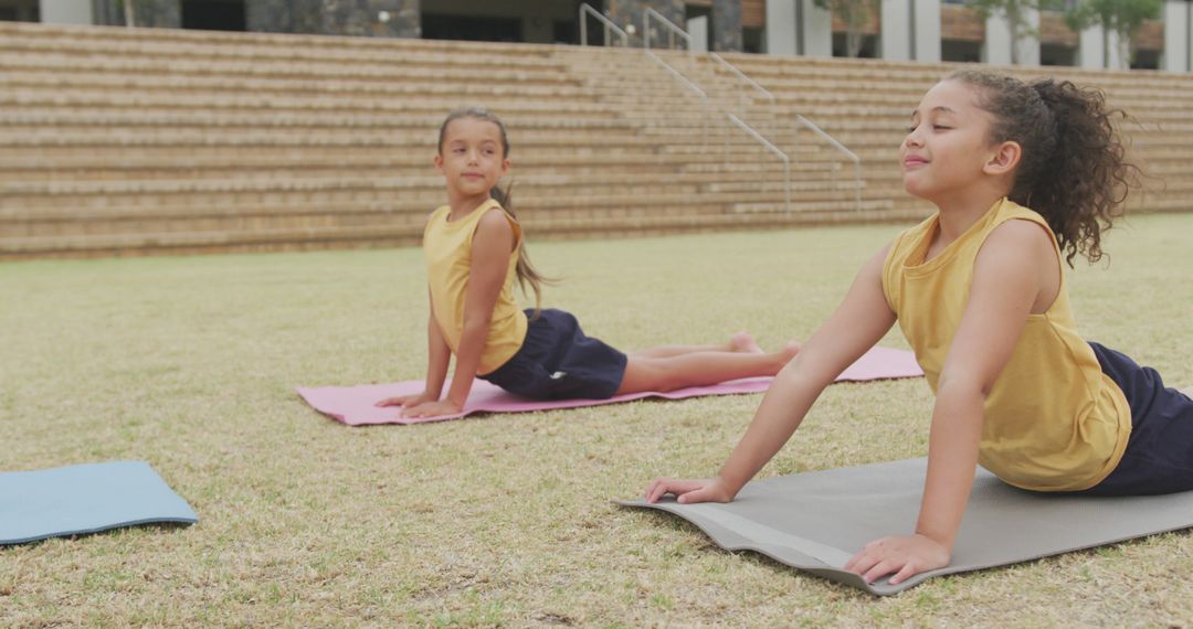 Two Young Girls Doing Yoga Exercises Outdoor in Park - Free Images, Stock Photos and Pictures on Pikwizard.com