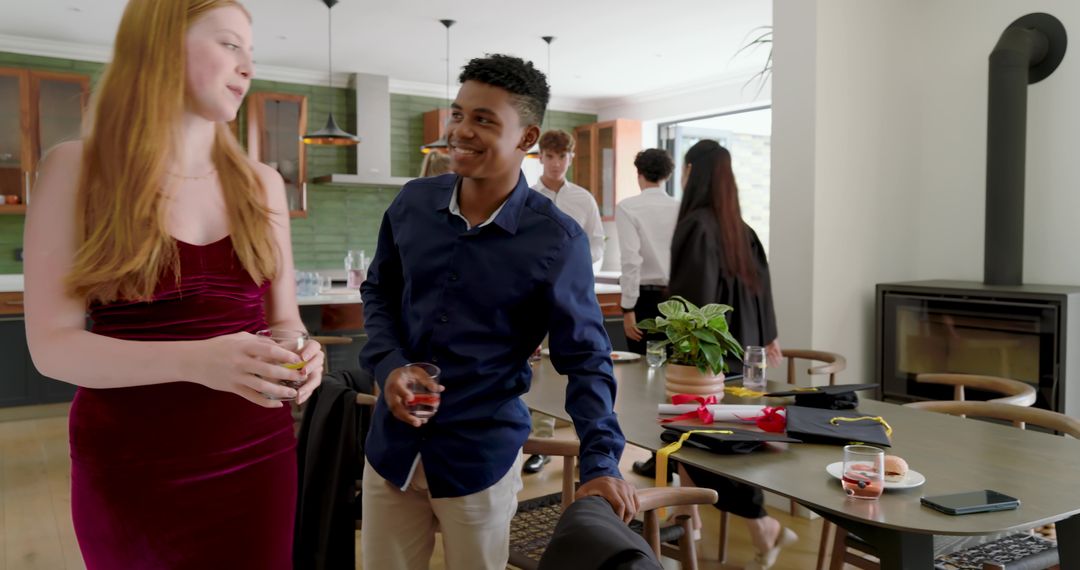 Multiracial High School Graduates Celebrating at Home with Diplomas and Toasts