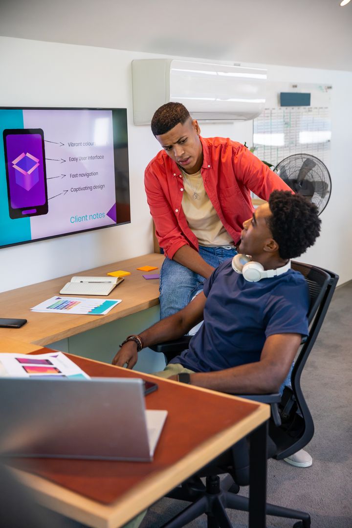 Diverse Team Collaborating on Mobile App Prototype at Workplace