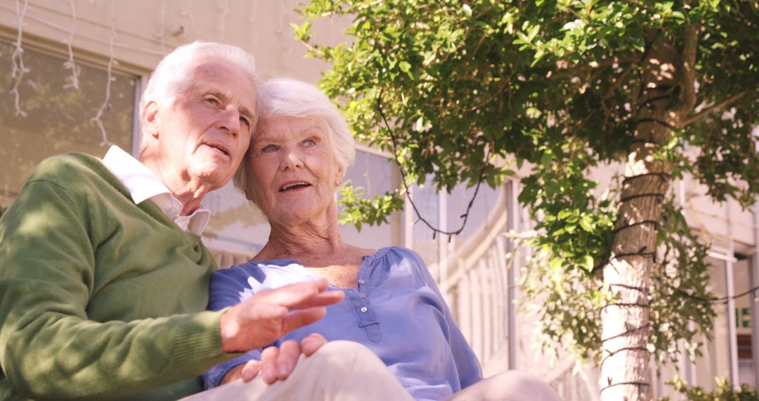 Senior Couple Relaxing on Bench Under Tree in Sunlit Garden - Free Images, Stock Photos and Pictures on Pikwizard.com