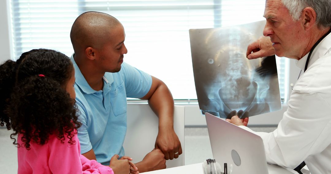 Doctor Explaining X-ray Results to Concerned Family in Clinic - Free Images, Stock Photos and Pictures on Pikwizard.com