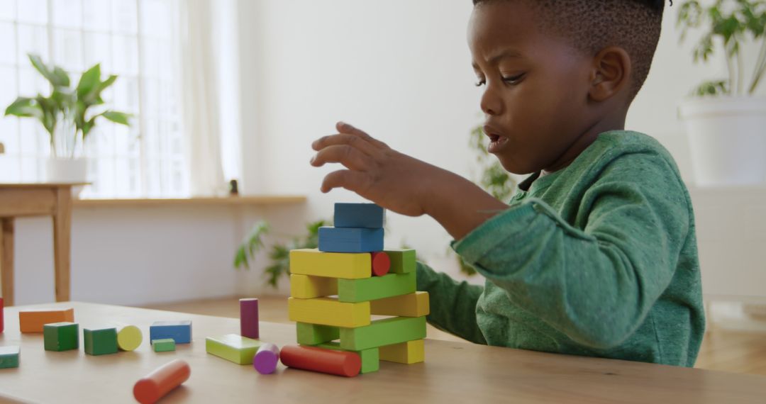 Young Boy Building Colorful Block Tower at Home - Free Images, Stock Photos and Pictures on Pikwizard.com