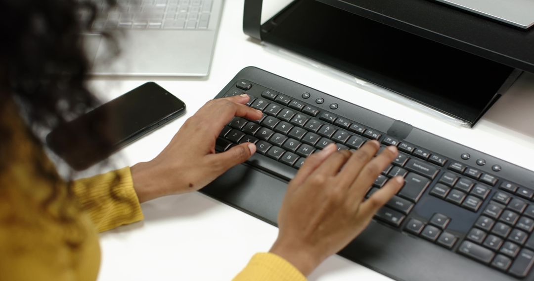 Hands Typing on Keyboard at Office Desk