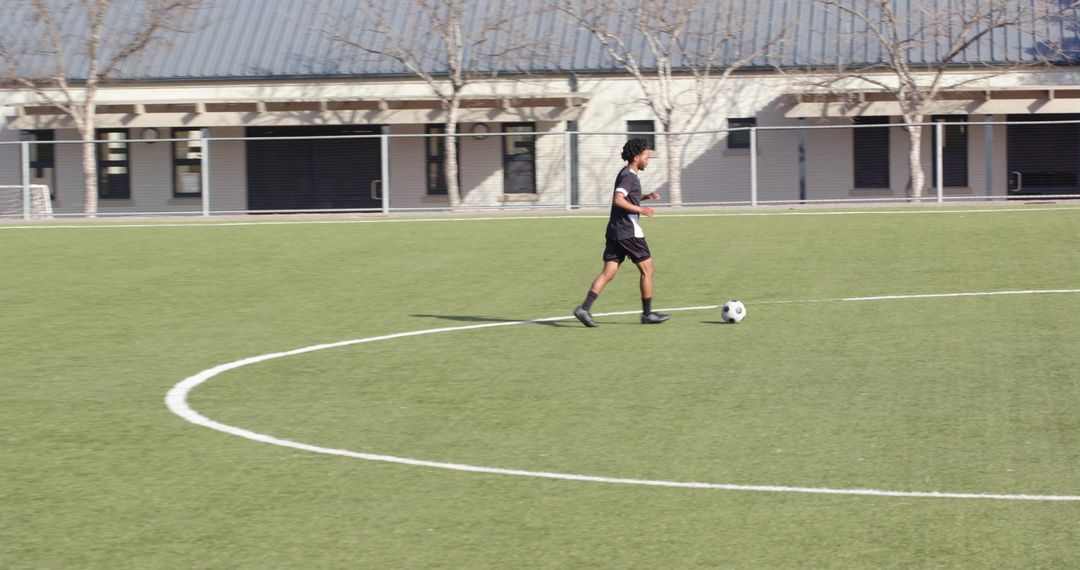 Lone Male Soccer Player Dribbling on Sunny Field