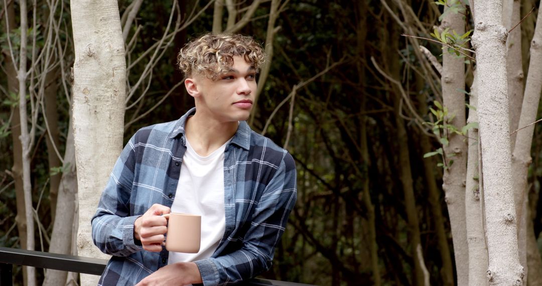 Man Relaxing with Coffee Mug in Wilderness