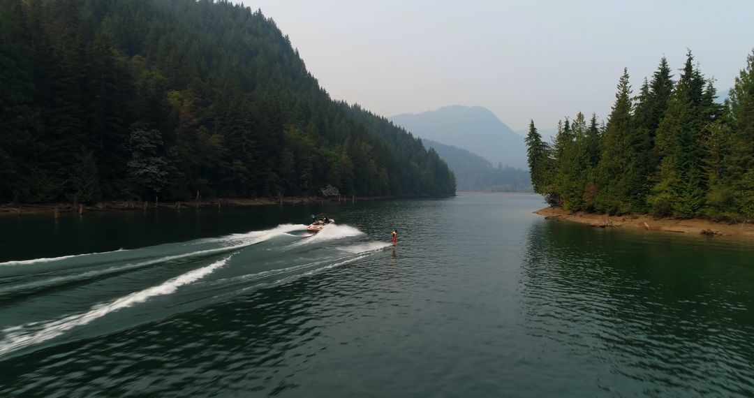 Boat Water Skiing in Serene Mountain Lake - Free Images, Stock Photos and Pictures on Pikwizard.com