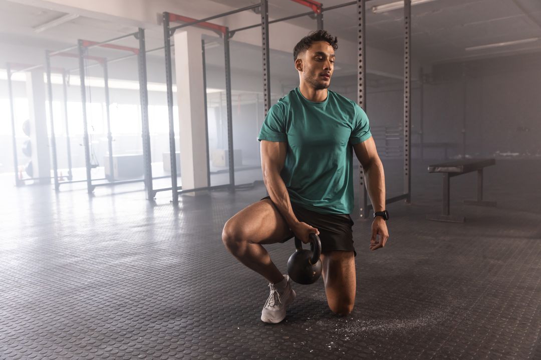 Man Kneeling with Kettlebell in Modern Gym Setting