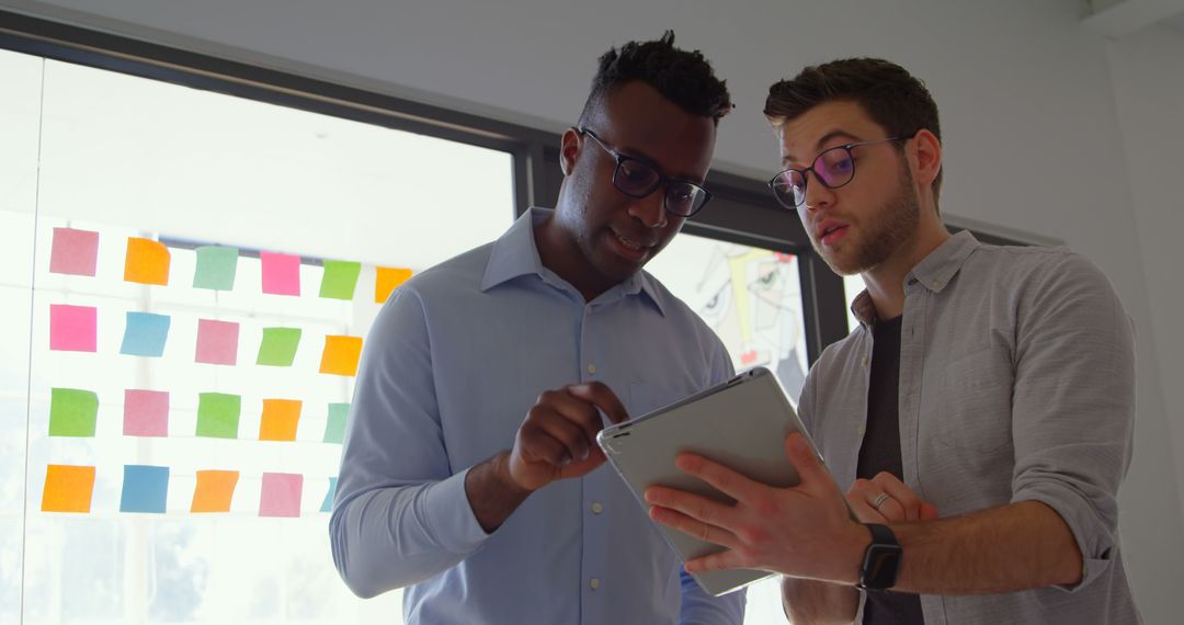 Collaborative Colleagues Discussing Strategy with Tablet in Modern Office