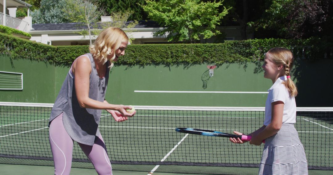 Mother Teaching Daughter to Play Tennis on Sunny Day - Free Images, Stock Photos and Pictures on Pikwizard.com