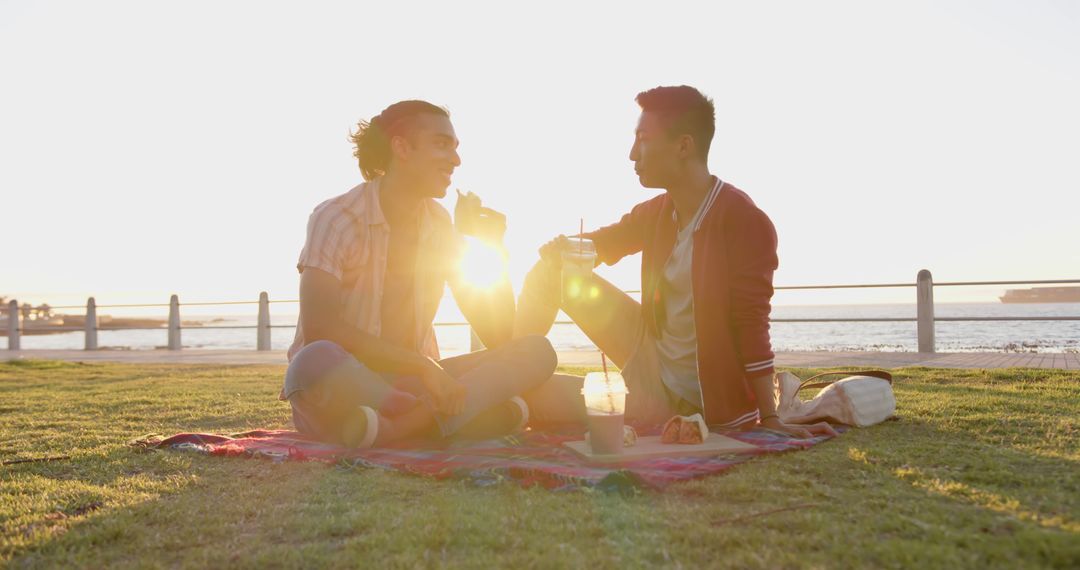 Couple Enjoying Picnic at Sunset by the Sea - Free Images, Stock Photos and Pictures on Pikwizard.com