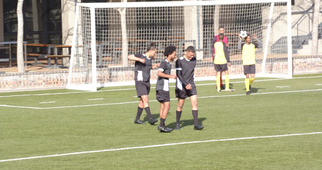 Soccer Players Practicing on Field with Enthusiastic Team Spirit