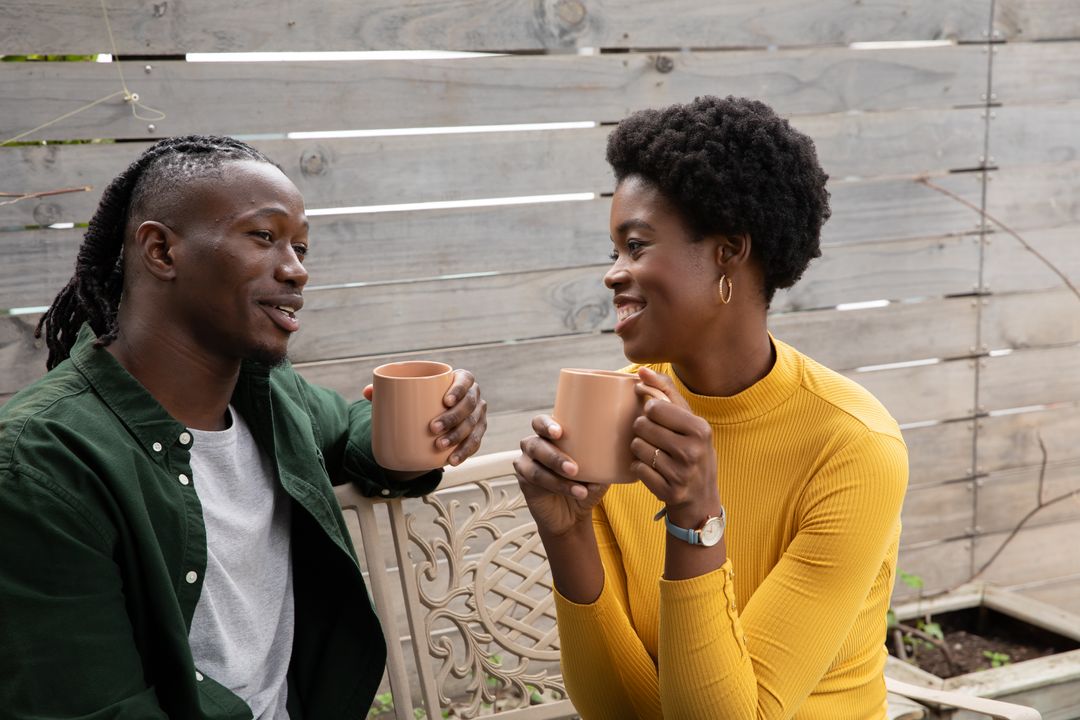 Couple Enjoying Coffee on Patio Bench in Cozy Atmosphere