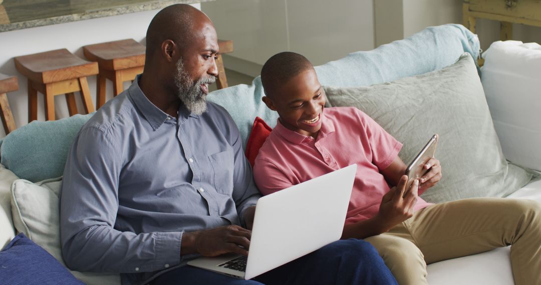 Image of happy african american father and son using laptop together - Free Images, Stock Photos and Pictures on Pikwizard.com
