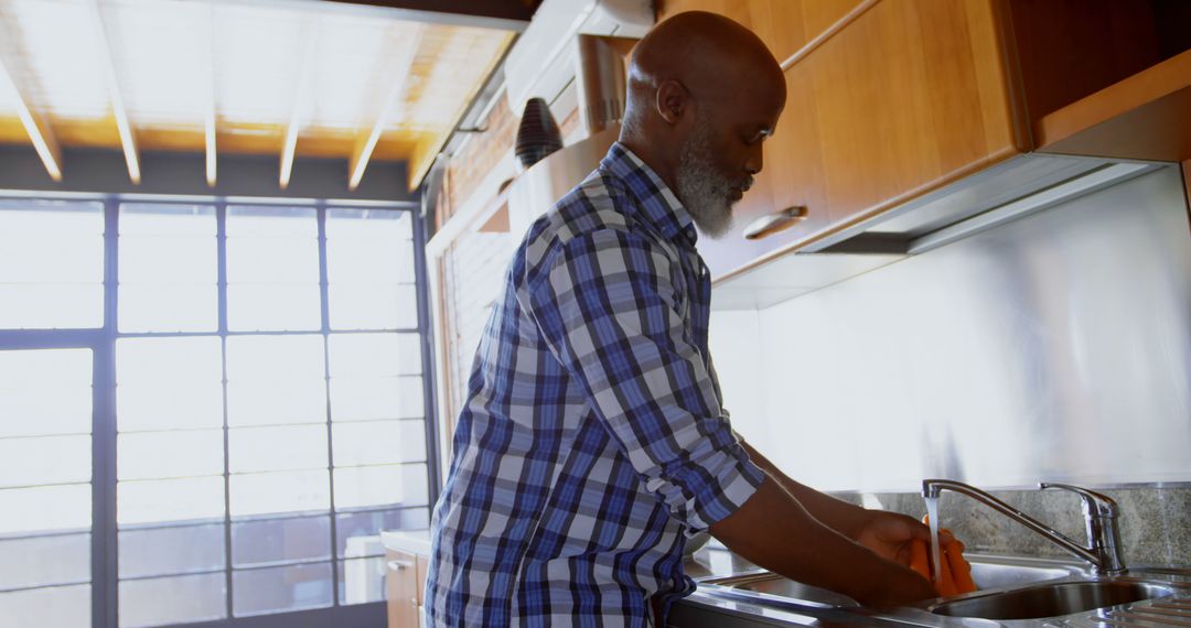 Senior African American Man Washing Dishes in Modern Kitchen - Free Images, Stock Photos and Pictures on Pikwizard.com