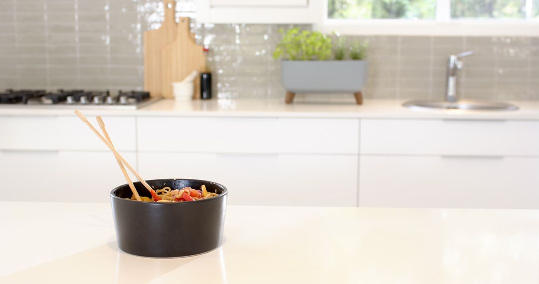 Black Bowl of Pasta on White Counter in Modern Kitchen