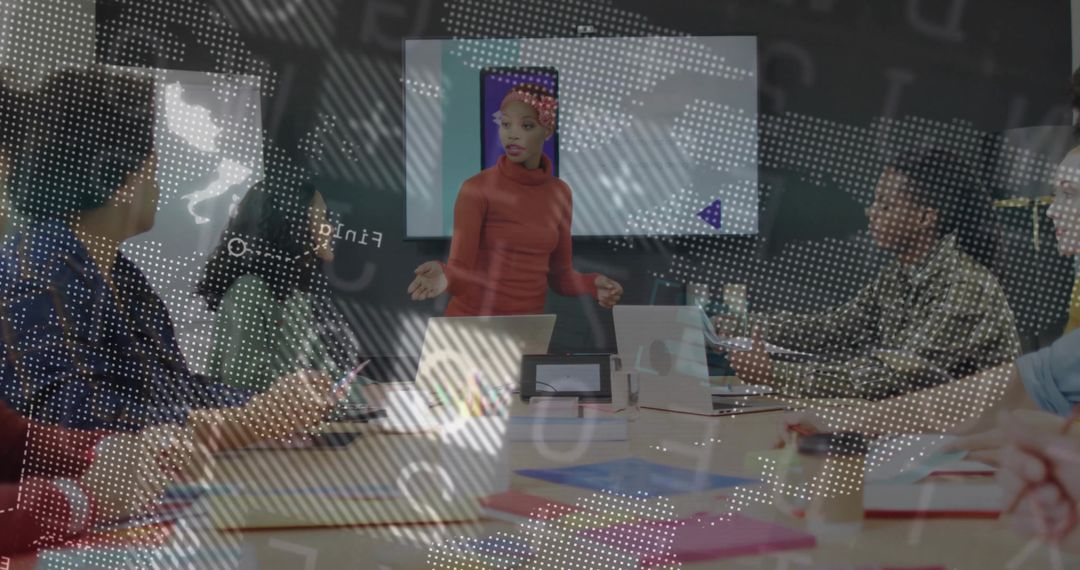 Woman presenting at conference table leading team meeting with laptops and charts