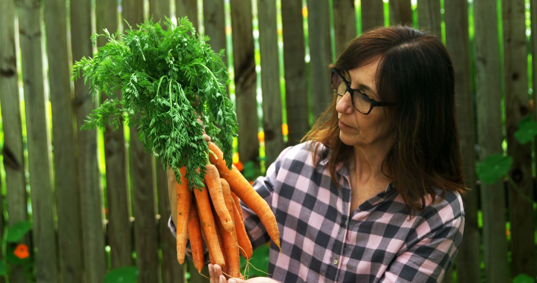 Caucasian woman holding carrots in garden with copy space - Free Images, Stock Photos and Pictures on Pikwizard.com