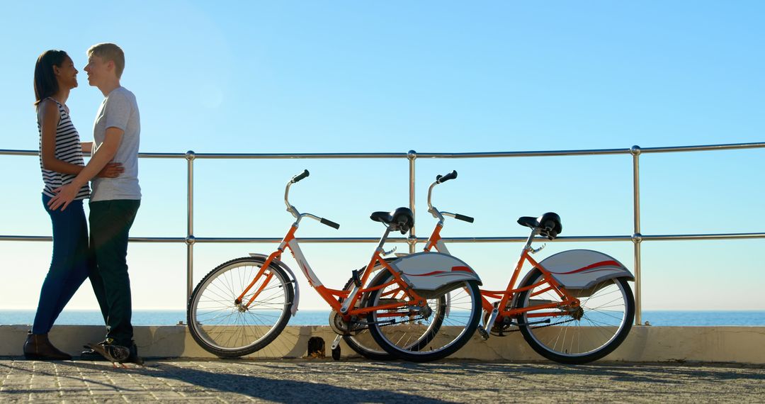 Young Couple Embracing at Oceanfront with Bicycles - Free Images, Stock Photos and Pictures on Pikwizard.com