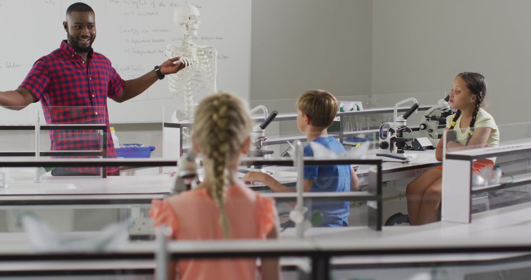 Image of happy african american teacher with class of diverse pupils during anatomy lesson - Free Images, Stock Photos and Pictures on Pikwizard.com