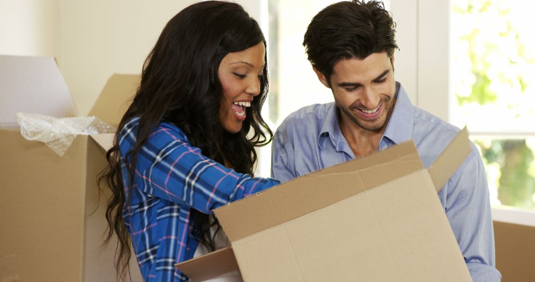 Smiling Couple Unpacking Moving Boxes in New Home - Free Images, Stock Photos and Pictures on Pikwizard.com