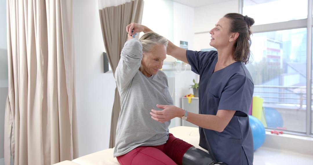 Physical Therapist Assisting Elderly Woman with Prosthetic Leg in Clinic - Free Images, Stock Photos and Pictures on Pikwizard.com