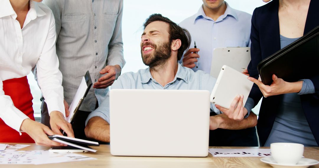 Overwhelmed Businessman at Desk with Multiple Tasks from Colleagues - Free Images, Stock Photos and Pictures on Pikwizard.com