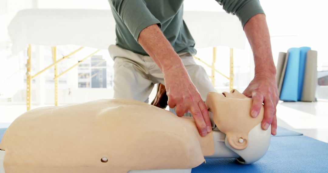 Instructor Demonstrating CPR on Mannequin for Emergency Training - Free Images, Stock Photos and Pictures on Pikwizard.com