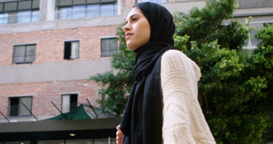 Confident Young Muslim Woman Walking Outdoors in Urban Setting - Free Images, Stock Photos and Pictures on Pikwizard.com