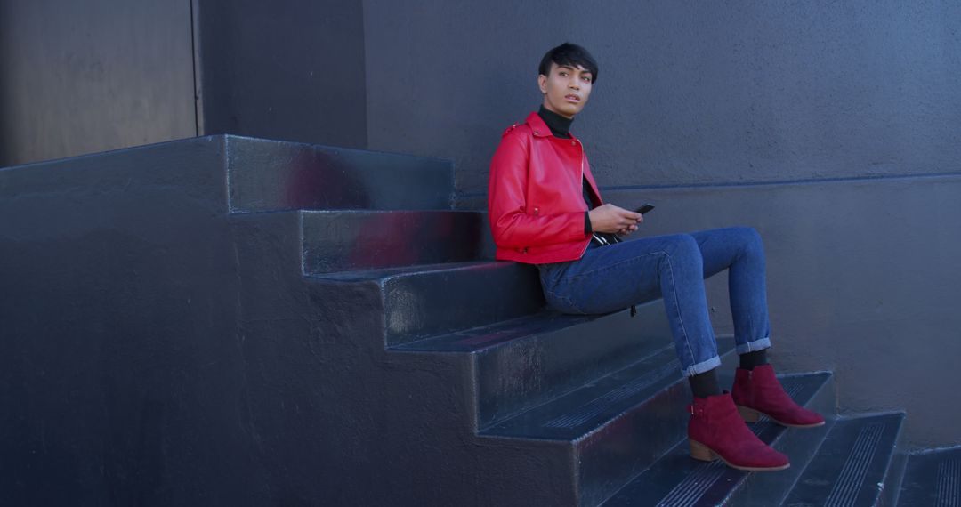 Fashionable Young Woman Sitting on Urban Staircase in Red Leather Jacket - Free Images, Stock Photos and Pictures on Pikwizard.com