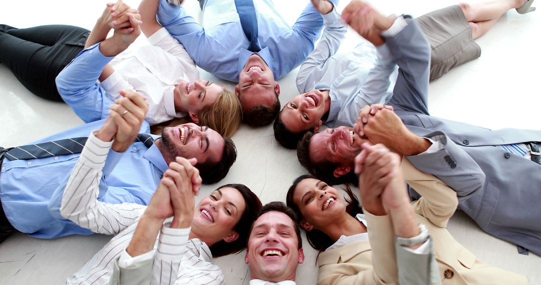 Team Members Lying In Circle Holding Hands Smiling - Free Images, Stock Photos and Pictures on Pikwizard.com