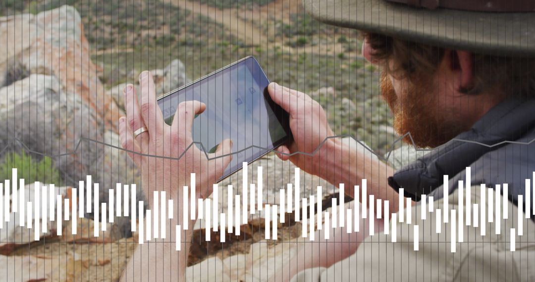 Hiker Using Tablet for Data Analysis in Mountainous Terrain