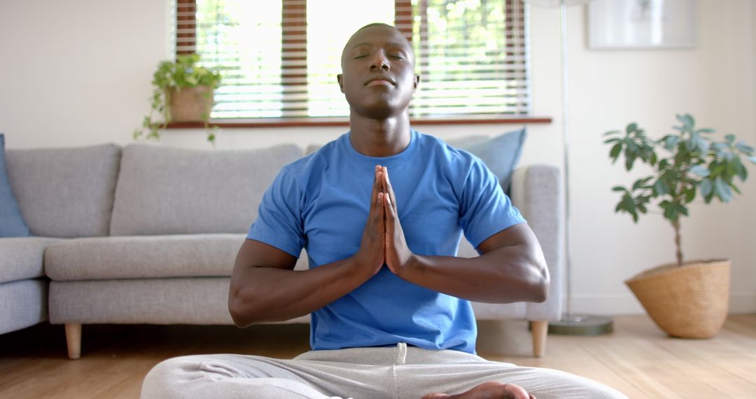 Man Meditating Cross-Legged in Tranquil Living Room Setting
