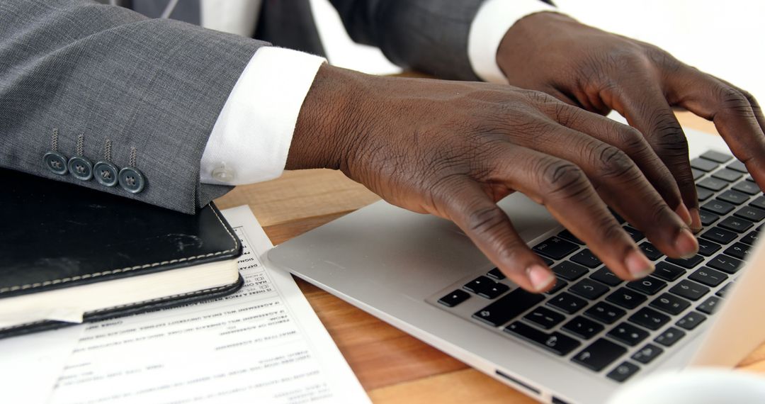 Business Professional Typing on Laptop with Documents