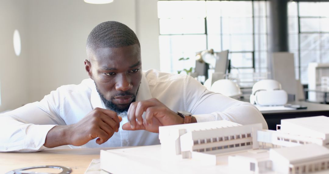 Architect Analyzing Building Model in Modern Office Setting