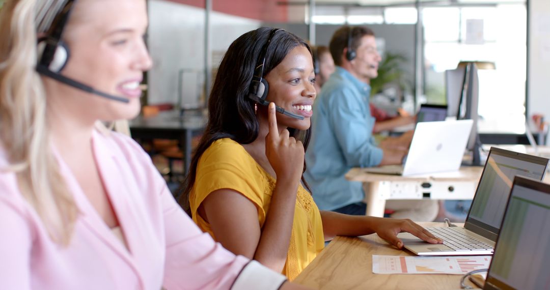 Diverse Customer Support Team Working on Laptops in Modern Office