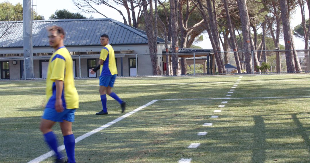Soccer Players in Yellow Jerseys Training on Sunny Field