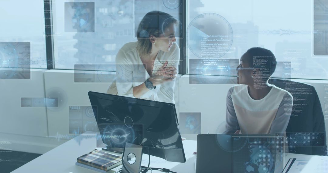 Female colleagues collaborating at urban office with laptop, monitor and data HUD overlay